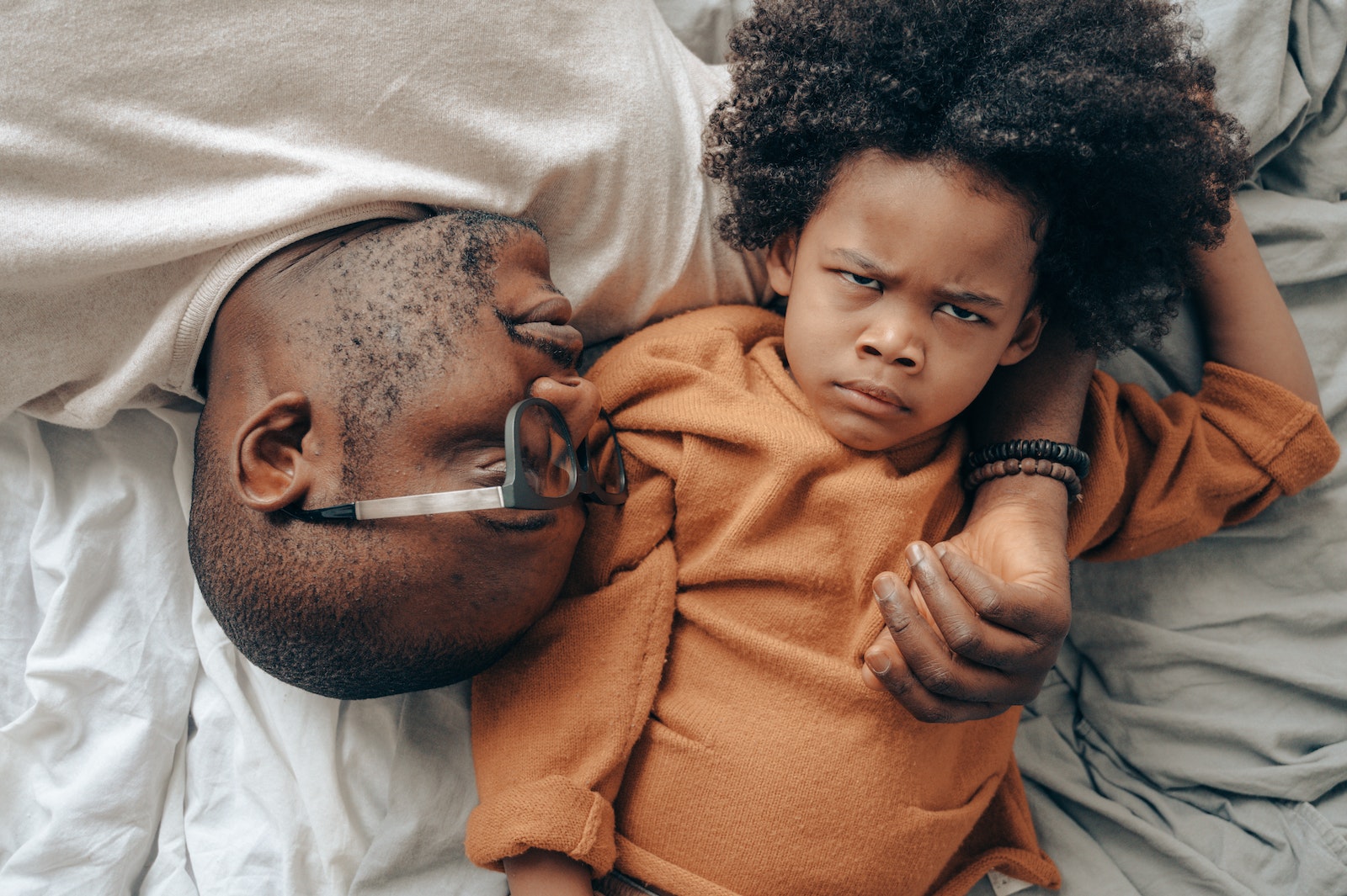 African American man lying near angry child